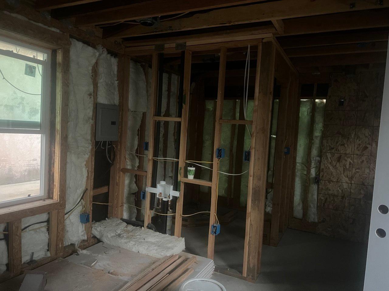 New framing, electrical, and plumbing rough-in for the kitchen and bathroom (during construction)