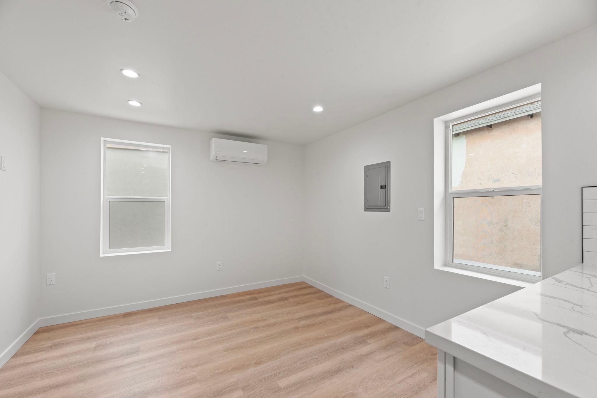 Studio living area with ductless mini-split and luxury vinyl plank flooring (after)