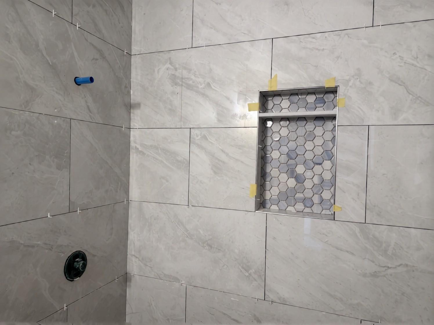 Shower niche with hex mosaic, tape still on during tiling