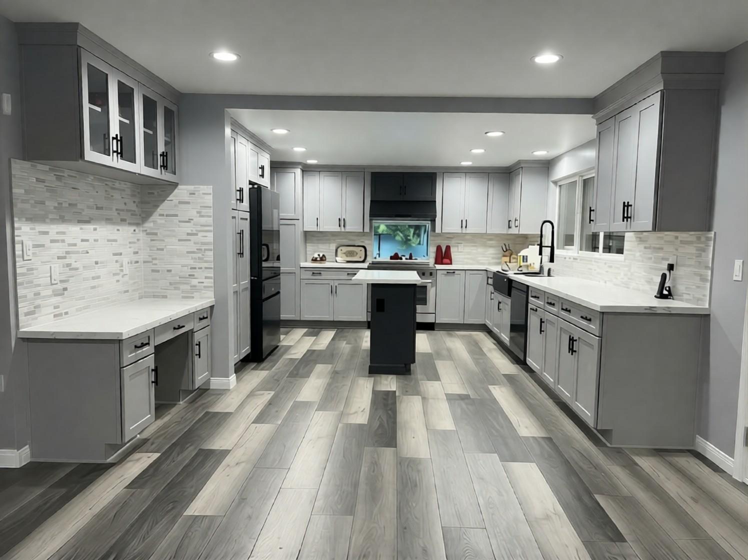 Finished Orange kitchen with gray shaker cabinets, a black island, recessed lighting and gray wood-look plank flooring